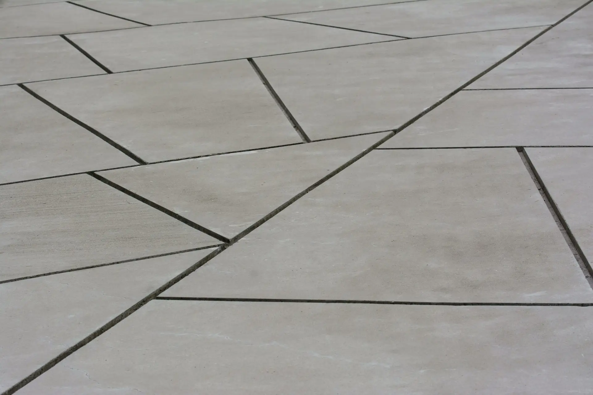 Abstract geometric concrete surface showing intersecting lines and shapes, ideal for backgrounds.
